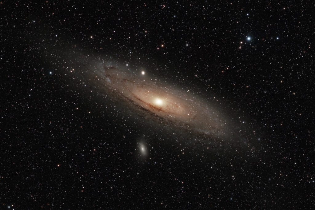 Astrofoto der Andromedagalaxie M31 mit hellem Galaxienkern, dunklen Staubbändern und den Begleitgalaxien M32 und M110