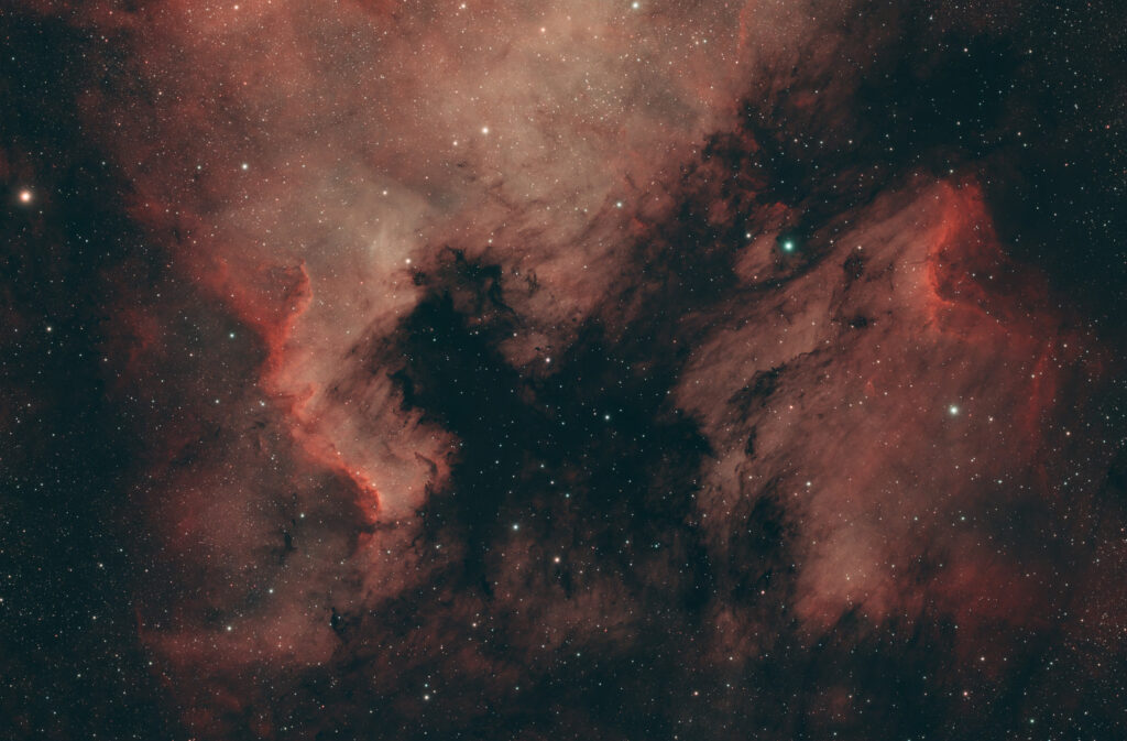 Astrofoto der Great-Wall-Region im Nordamerikanebel NGC 7000 mit IC 5070 Pelikannebel, H-alpha-Emissionen und dunklen Staubbändern
