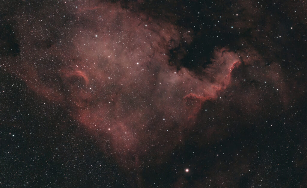 Astrofoto des Nordamerikanebels NGC 7000 im Sternbild Schwan mit roten Emissionsnebeln und dunklen Staubstrukturen